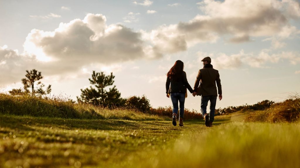 Couple walking along the cotswold way.