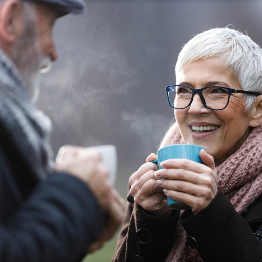 Old people enjoying a warm drink on a cold day.