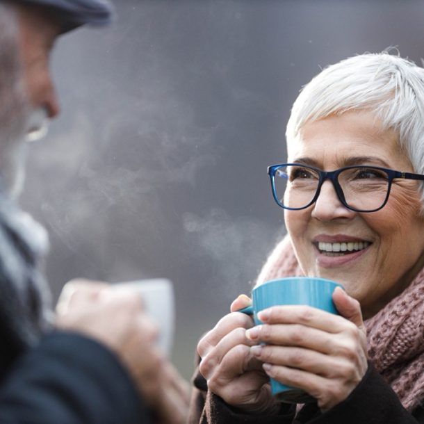 Old couple drinking hot drinks in cold weather