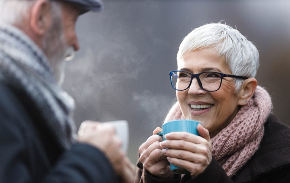 Old couple drinking hot drinks in cold weather