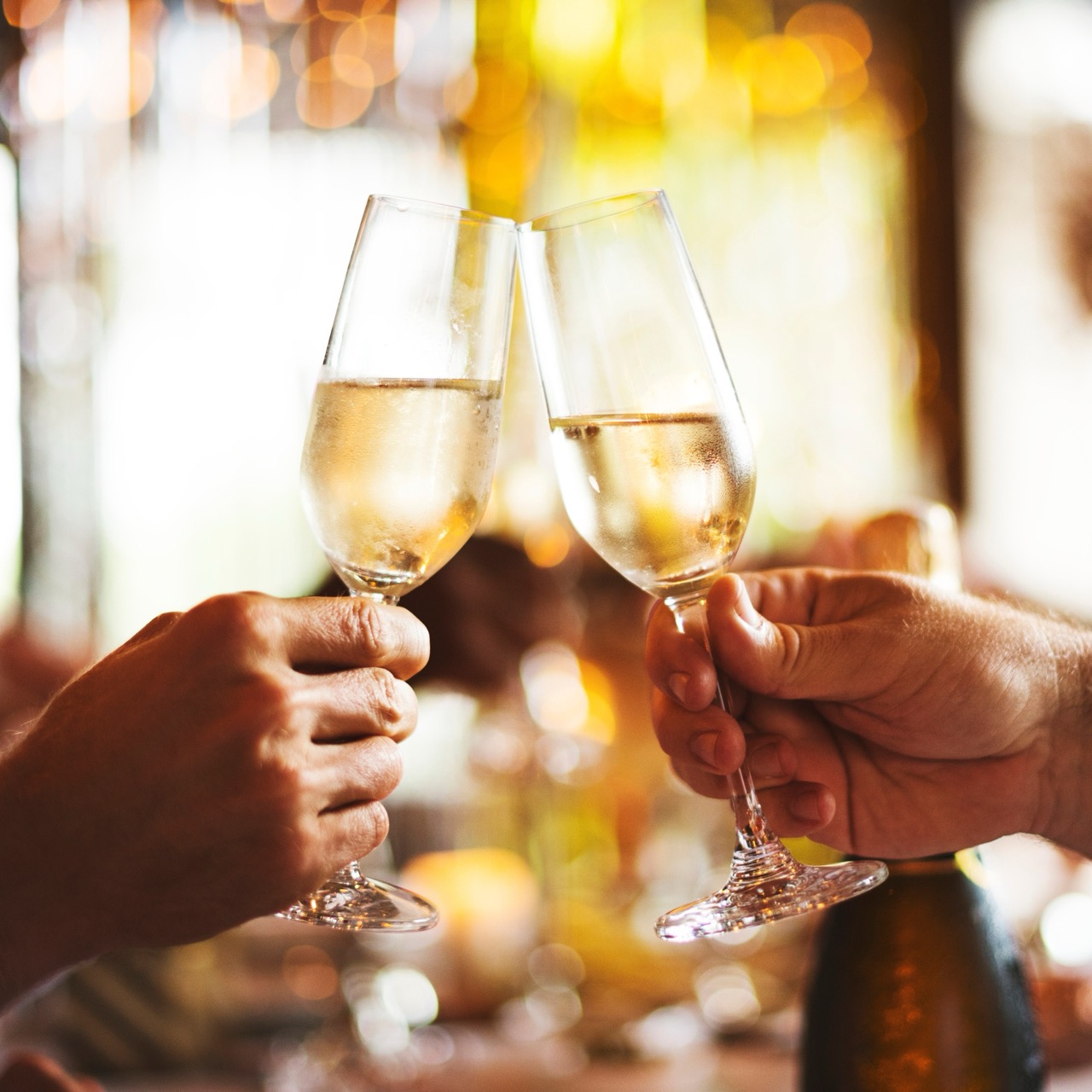 Two glasses of sparkling wine being raised in a toast for a cheers moment at hatton court hotel while at a baby shower.