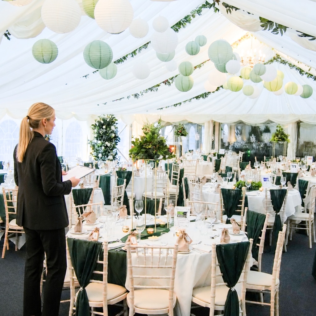 http://Wedding%20organiser%20looking%20out%20over%20a%20wedding%20about%20to%20happen%20in%20the%20marquee%20at%20hatton%20court%20hotel